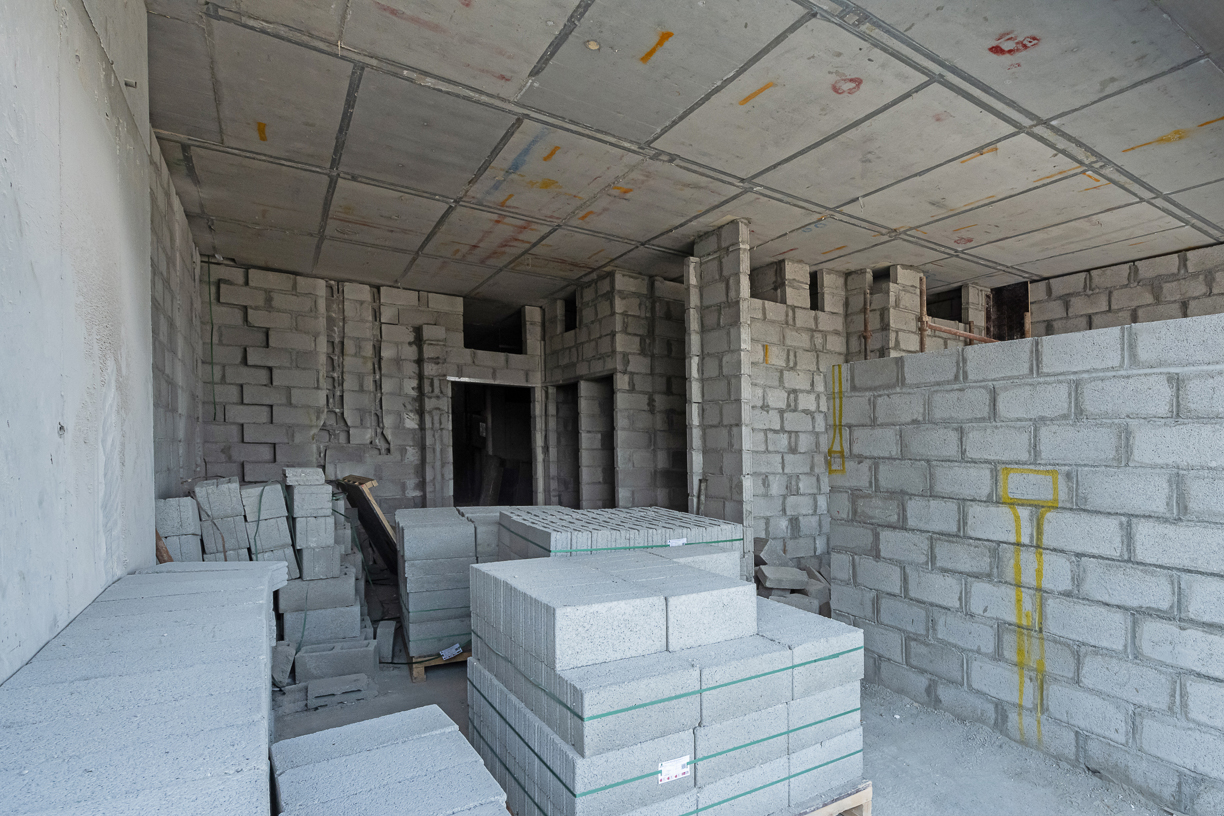 Pearl House By Imtiaz A construction site interior featuring stacks of concrete blocks and unfinished walls in a partially built structure.